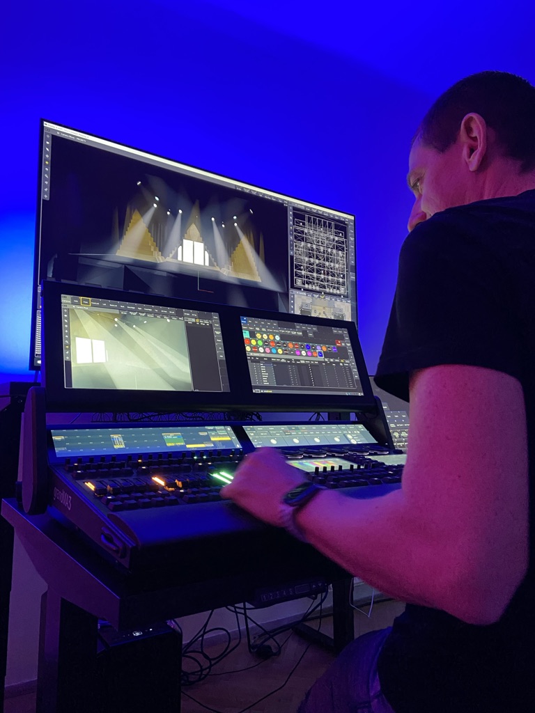 Techniker am Lichtpult – Mann bedient ein Lichtsteuerpult mit Monitoren.