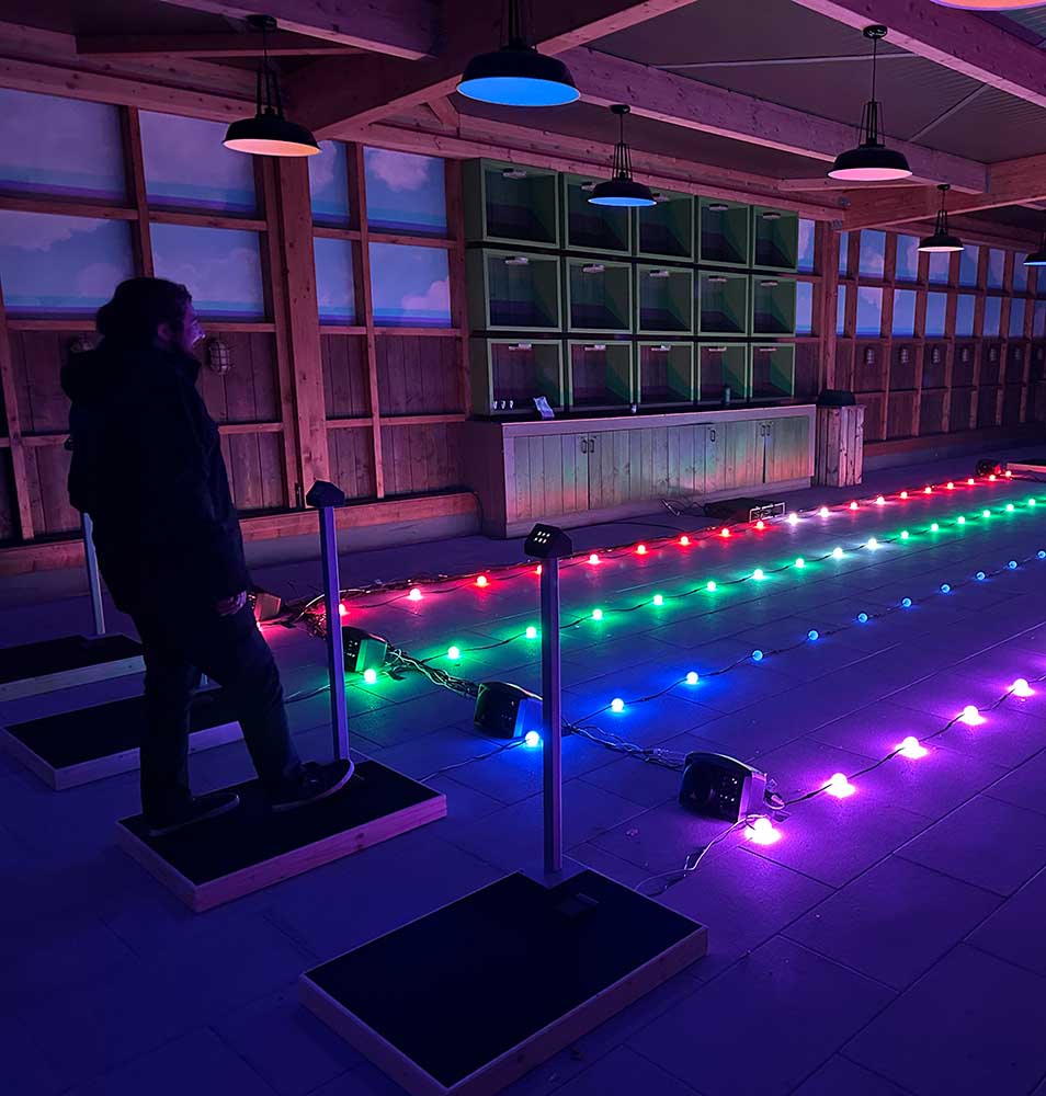 Interaktive Lichtinstallation mit Publikum – Besucher interagiert mit farbigen LED-Streifen.