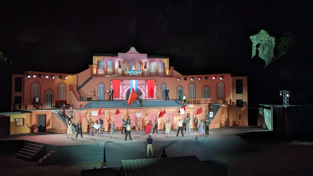 Open-Air-Bühne Nacht – Schauspieler auf beleuchteter Bühne bei Nacht.